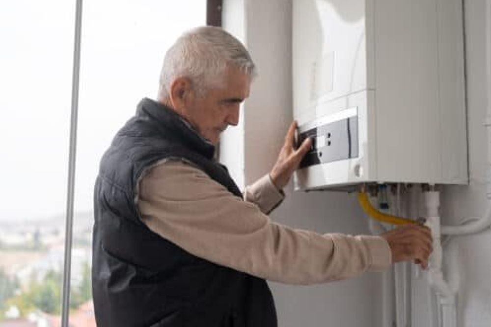 Man adjusting home boiler system for heating efficiency.